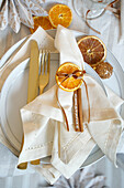 Christmas table setting with a cinnamon stick as a name tag and dried orange slices