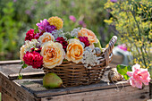 Bouquet of roses (pink), dahlias (Dahlia), wild carrot in wicker basket