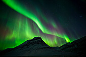 Northern lights above snowy mountains, Iceland