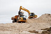Coastal dunes being reshaped by mechanical digger