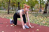 Young woman practicing sprint start