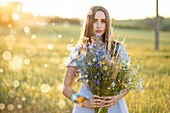 Woman with bouquet of flowers in a field