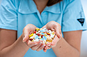 Woman holding pile of pills