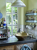 Country-style kitchen with unusual sink and spice racks by the window