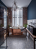 Bathroom with copper bathtub, chandelier and patterned tiles