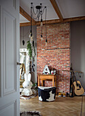 Room with rabbit lamp, brick wall, cowhide stool and guitar