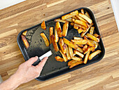 Turning fries on a baking tray