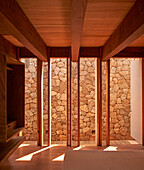 Bedroom with view of stone wall, wooden elements, Casa Cometa, Mexico