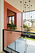 Modern house with coral red wall and glass railings