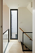 Hallway with wooden banister and elongated window