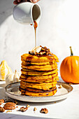 Pumpkin pancakes with pecans and maple syrup