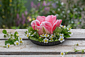 Tulpe 'Angelique' (Tulipa) zwischen Erdbeerblüten als Kranz auf Terrassentisch