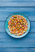 Colourful superfood bowl with pomegranate, mango and nuts