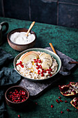 Porridge with apple slices, yoghurt and pomegranate seeds