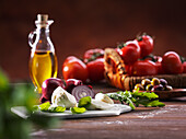 Ingredients for pizza topping - tomatoes, mozzarella, red onions, oil, olives
