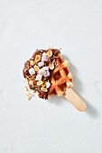 Waffle pops with chocolate icing, nuts and marshmallows