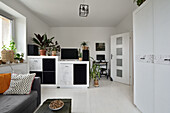 Modern eingerichtetes Studio mit Zimmerpflanzen und weißem Interieur