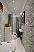 Kleines Badezimmer mit Mosaikfliesen, Duschkabine und Toilette