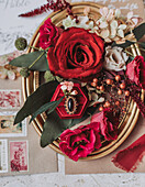 Arrangement of roses, berries and jewelry on a golden tray