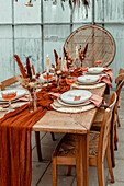 Dining table set with autumn decorations, dried flowers and candles