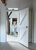 White tiled bathroom with wooden beams and open vintage stable door