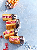 Waffle ice cream sandwich with raspberries and chocolate icing