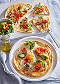 Pizza with tomatoes, egg, rocket and mozzarella