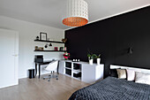 Bedroom with black accent wall, desk and white sideboard