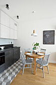 Kitchen with wooden dining table and chairs in grey tones