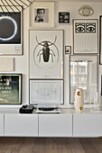 Wall design with framed posters above a modern sideboard with record player