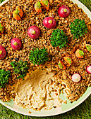 Hummus with herbs and vegetable decoration