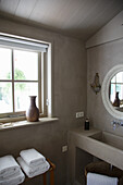 Bathroom in light brown with modern washbasin and window sill decoration