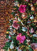 Lavishly decorated Christmas tree with ornaments and floral accents