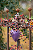 Herz an Gartenzaun hängend mit Wildem Wein im Herbst