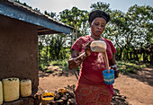 Woman mixing porridge, Kenya