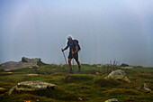 Man walking in hills near mountain