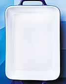 Empty white casserole dish on a blue background