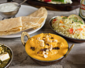 Indian butter chicken with rice and papadam
