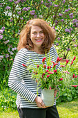 Woman with bouquet of incarnate clover (Trifolium incarnatum) and grasses