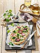 Tarte flambée with spring herbs and red onions