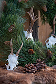 Wreath of pine and cones with fur and deer antlers on woodpile