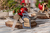 Rustikale Tischdekoration im Advent mit Hirsch, Baumscheibe, Tannenzweige, Filzkarte und Apfel
