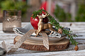 Rustikale Tischdekoration im Advent mit Hirsch, Baumscheibe, Tannenzweige und Apfel