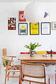 Dining room with wooden table, paper lamp and picture wall