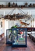 Large dining table with wreath of dried flowers and glass container with decorative objects