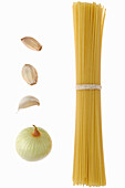 Bundle of spaghetti with garlic cloves and onion