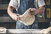 Bäcker formt handgemachten Sauerteig für Brot