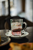 Tea bag with hibiscus in a glass cup, served on a wooden table