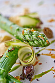 Grüner Spargel mit Zucchini, kandierter Zedrat und schwarzen Oliven