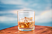 Whisky on the rocks on a wooden table